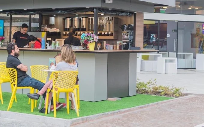 Barra Bübble tea en operación: dispensadores, selladora y dos personas atendiendo a clientes sentados