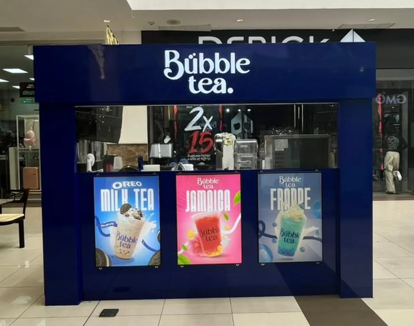Isla Bübble tea operando en el pasillo de un centro comercial, con su vitrina y tres afiches de producto